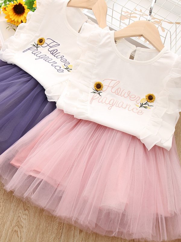 طقم مكون من قطعتين: بلوزة مطرزة بحروف الأبجدية الإنجليزية وزهرة عباد الشمس، وتنورة شبكية.