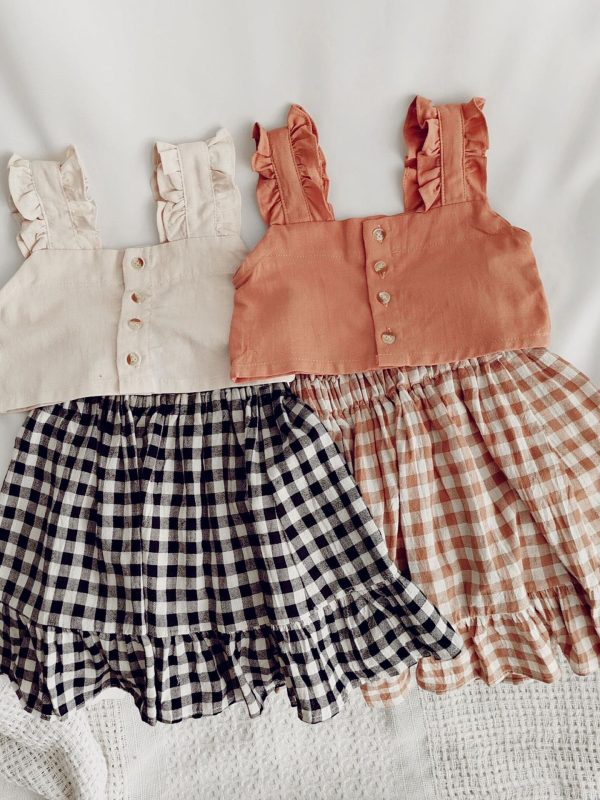 بلوزة قصيرة مع حمالات وتنورة كاروهات