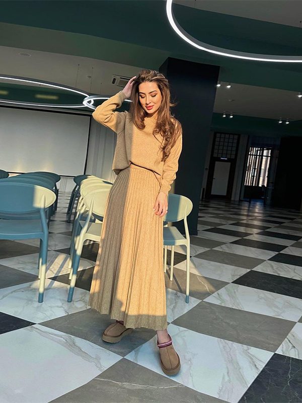 طقم تنورة نسائية أنيقة بأكمام طويلة وقصة مطوية، بياقة دائرية ولون موحد.